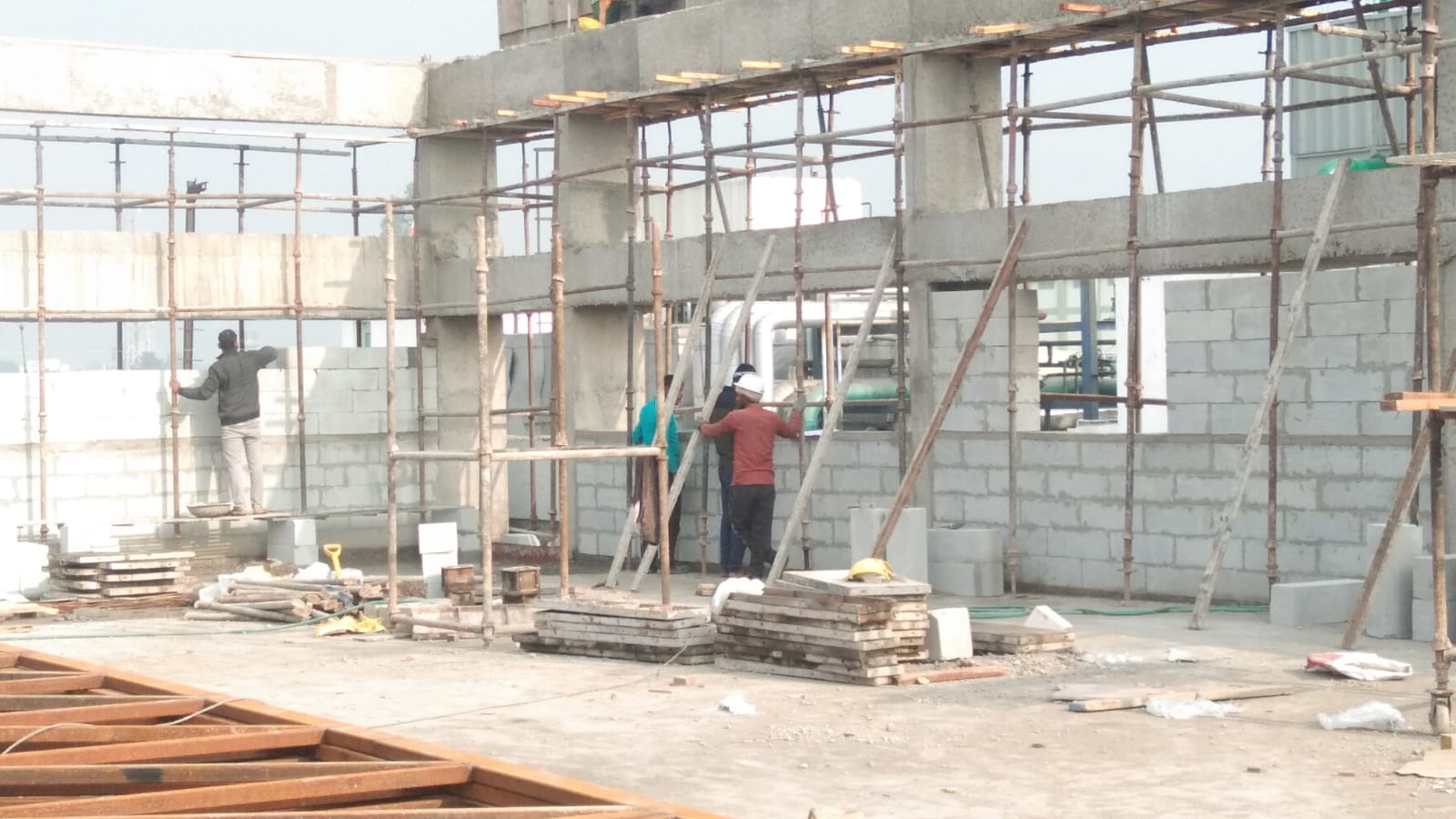 Masonry team building block walls within a concrete structural frame